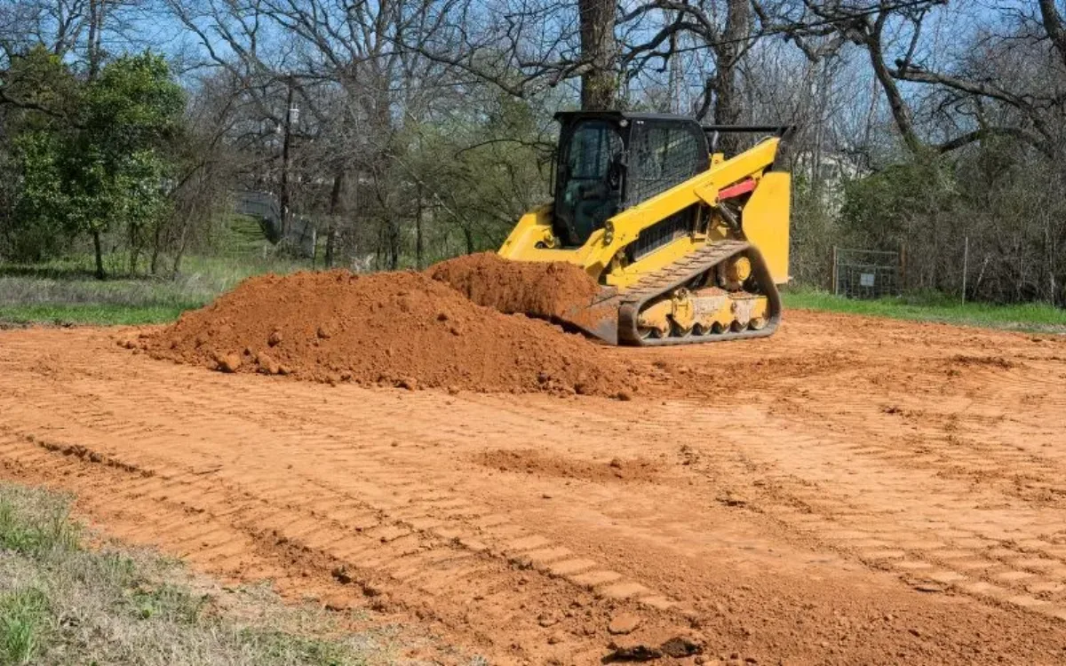 Equipment performing site preparation and dirt work on a rural Northeast Louisiana property