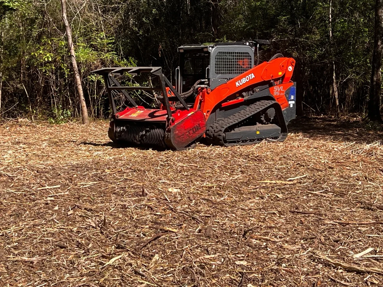 A forestry mulcher clearing a wooded acre on rural Northeast Louisiana land